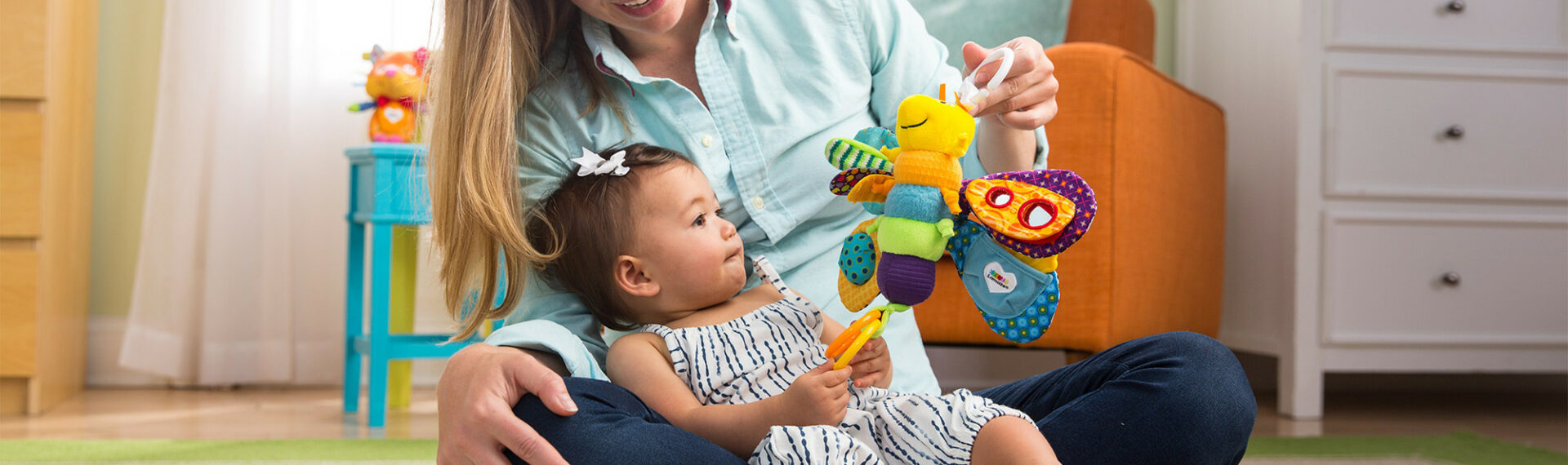 Mutter mit Kind im Arm und Freddie das Glühwürmchen Spielzeug