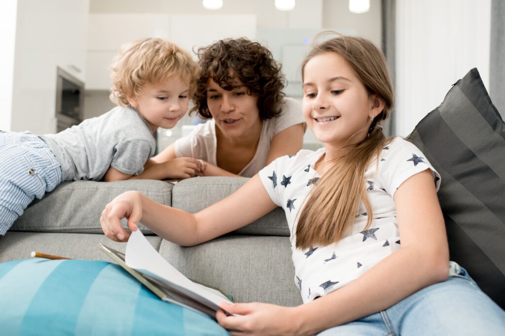 Alleinerziehende Mutter, die mit ihren Kindern am Küchentisch sitzt und den Tagesplan organisiert.