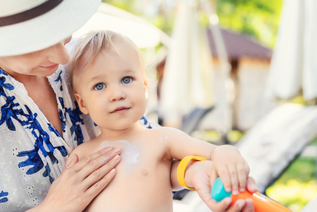 2.	Baby mit UV-Schutzkleidung und mineralischer Sonnencreme, sicher in der Sonne – Sonnenschutz für Babys.