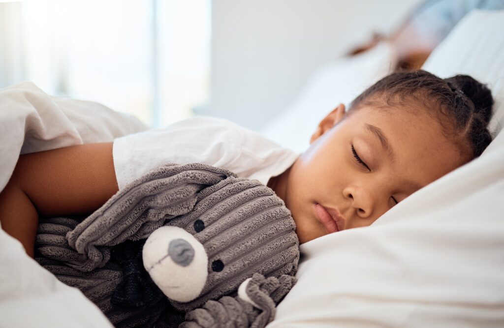 Kind schläft friedlich im Bett – Wie viel Schlaf brauchen Kinder